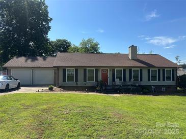 Charming single-story home featuring a well-manicured lawn, attached garage, and welcoming red front door at 2401 Hoffman St, Gastonia, NC 28054