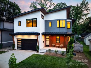 Stunning modern home with a two-car garage and a welcoming front porch with two chairs at 4108 Commonwealth Ave, Charlotte, NC 28205