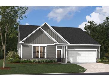 Charming single-story home with gray siding, stone accents, and a well-manicured lawn and attached two car garage at 5111 Raging Creek Dr, Indian Trail, NC 28079