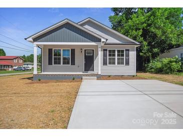 Charming single-story home featuring a covered front porch and a freshly poured concrete driveway at 528 S Caldwell St, Salisbury, NC 28144