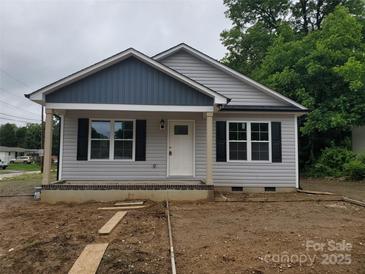 Charming single-story home with gray siding, black shutters, and a covered front porch, ready for landscaping at 528 S Caldwell St, Salisbury, NC 28144