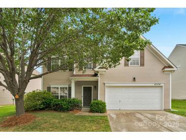 Charming two-story home features a well-manicured lawn, mature trees, and a two-car garage at 6104 Follow The Trl, Indian Trail, NC 28079