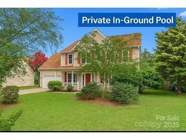 Charming two-story home with red shutters, covered porch and manicured lawn at 6614 Truman St, Indian Trail, NC 28079