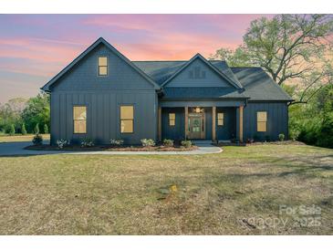 Charming single Gathering home featuring a craftsman style elevation, well manicured lawn and inviting front porch at 919 Village Lake Dr, Monroe, NC 28110