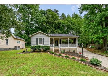 Charming single-story home features a welcoming front porch, well-maintained lawn, and beautiful landscaping at 107 Oakland Rd, Belmont, NC 28012
