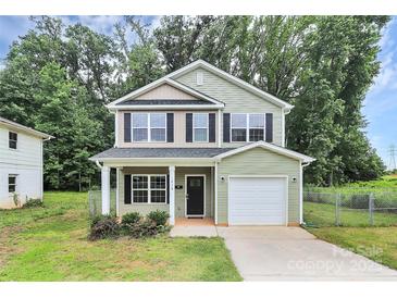 Charming two-story home with light green siding, black shutters, and an attached one car garage at 1218 Rosada Dr, Charlotte, NC 28213