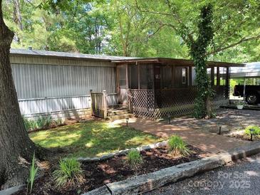 Charming home featuring a lovely screened-in porch and landscaped front yard at 189 6Th Ave, New London, NC 28127