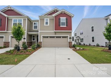 Two-story home featuring a two-car garage, stone accents, and well-maintained landscaping at 2021 Vinyasa Ln # Sts-41, Charlotte, NC 28215