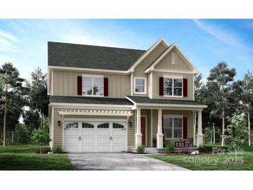 Charming two-story home featuring a covered front porch, attached garage, and beautifully landscaped front yard at 20392 Queens St, Cornelius, NC 28031