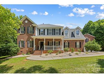 Charming two-story brick home with a welcoming front porch and well-manicured lawn at 220 Glenville Dr, Fort Mill, SC 29715