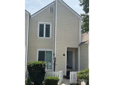 Traditional two-story townhouse featuring neutral siding, white trim, and charming picket fence at 303 Eastwood Dr, Salisbury, NC 28146