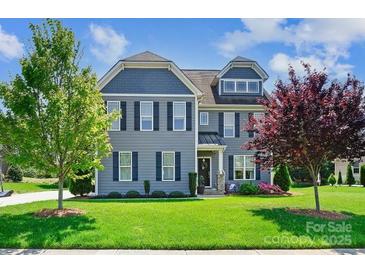 Beautiful two-story home with lush green lawn, attractive landscaping and trees at 4151 Green Park Ct, Harrisburg, NC 28075