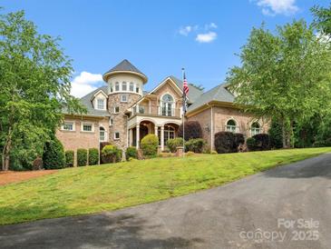 Elegant brick home with a turret, manicured lawn, and a welcoming driveway at 6742 Charlotte Hwy, York, SC 29745