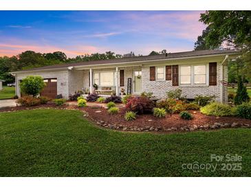 Charming brick home featuring a meticulously landscaped front yard and a welcoming front porch at 9135 Stokes Ferry Rd, Salisbury, NC 28146