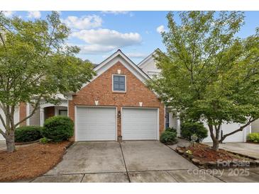 Home with a two-car garage and brick exterior surrounded by lush green trees at 10207 Garmoyle St, Charlotte, NC 28277