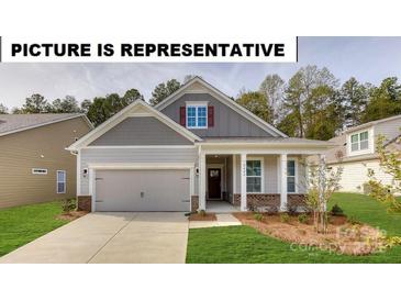 Charming one-story home featuring a welcoming front porch, attached garage, and well-maintained landscaping at 121 S Shayna Rd, Troutman, NC 28166