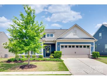 Charming blue two-story home featuring an attached garage, landscaped yard, and a welcoming entrance at 1636 Red Leaf Dr, Fort Mill, SC 29715