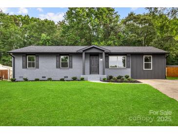 Charming, newly renovated home with a fresh gray exterior, updated windows, and lush green lawn at 316 Fulton St, Kings Mountain, NC 28086