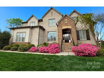 Charming brick home with manicured lawn and vibrant pink azaleas, creating a welcoming curb appeal at 324 Squash Harvest Ct, Matthews, NC 28104