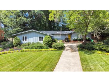 Charming single-story home featuring lush landscaping, manicured lawn and a bright yellow front door at 331 Glen Oaks Rd, Charlotte, NC 28270