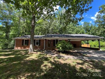 Charming brick home with attached carport nestled among mature trees at 511 Evelyn Ave, Kannapolis, NC 28083