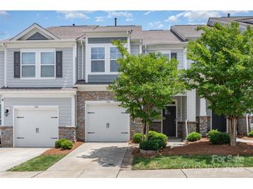 Charming townhome with stone accents, two-car garage, and landscaped front yard at 724 Little Bluestem Dr, Lake Wylie, SC 29710