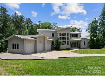 Striking modern home featuring a three-car garage, expansive windows, and a lush front lawn at 188 Blarney Rd, Mooresville, NC 28117