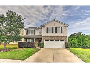 Charming two-story home featuring stone accents, a well-manicured lawn, and an attached two-car garage at 5011 Blue Stream Ln, Indian Trail, NC 28079