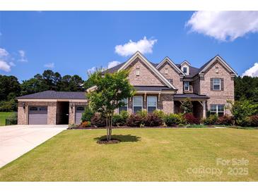 Beautiful brick home with a well-manicured lawn and mature landscaping, showcasing its curb appeal at 720 Cavesson Way, Monroe, NC 28110