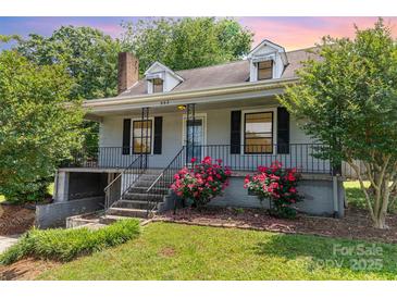 Charming home with landscaped front yard, featuring vibrant roses, inviting entrance, and classic architectural details at 952 8Th Ne St, Hickory, NC 28601