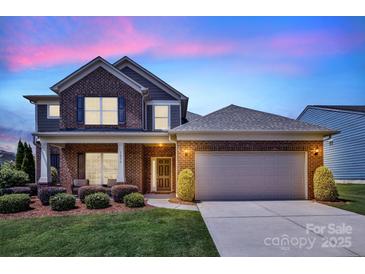 Charming two-story brick home with well-manicured lawn and attached two-car garage at 1036 Squire Dr, Fort Mill, SC 29707