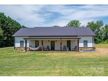 Charming single-story home with a covered front porch featuring a hammock and rocking chairs, surrounded by a lush green lawn at 1138 Zeb Haynes Rd, Maiden, NC 28650