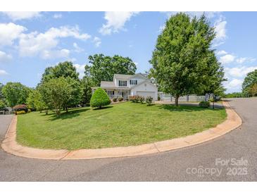 Charming home with a large yard, white picket fence and lush landscaping on a sunny day at 130 Greenwich Dr, Statesville, NC 28677