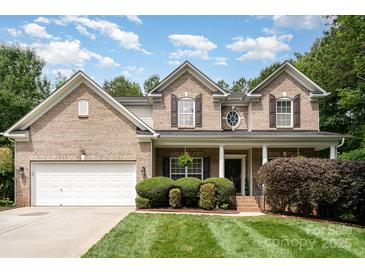 Charming brick home featuring a well-manicured lawn, attached two-car garage, and inviting front porch at 2504 Korbel Ct, Waxhaw, NC 28173