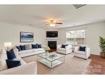 Bright living room with a cozy fireplace, plush seating, and a glass-top coffee table at 2515 Walnut Forest Dr, Charlotte, NC 28216