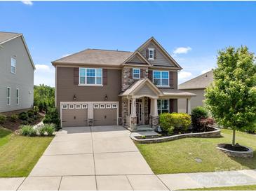 Beautiful two-story home featuring a two-car garage, manicured lawn and stone-accented facade at 2835 Berkhamstead Cir, Concord, NC 28027