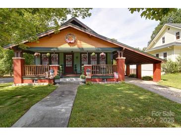 Charming home with a colorful exterior, inviting front porch, and convenient carport at 401 7Th St, Spencer, NC 28159