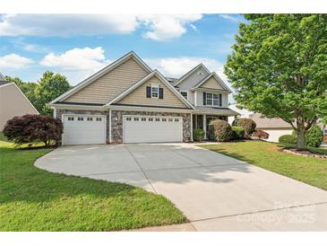Charming two-story home with a three-car garage and a well-manicured lawn at 4352 Haddington Dr, Fort Mill, SC 29707