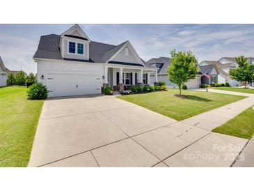 Charming two-story home with a two-car garage, well-manicured lawn, and inviting front porch at 4689 Kingswood Dr, Indian Land, SC 29707