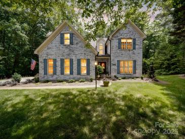 Charming white brick home with blue shutters, lush lawn, and manicured landscaping at 4715 Lenden Hall Ct, Gastonia, NC 28056