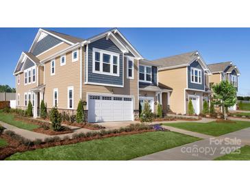 Charming townhome showcases manicured landscaping and a two-car garage on a sunny day at 7148 Hodges Meadow Ln, Charlotte, NC 28213
