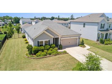 Beautiful single-story home with a well-manicured lawn and a two-car garage in a residential neighborhood at 8406 Flint Hill Dr, Charlotte, NC 28273