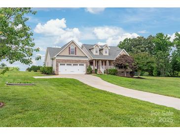 Charming home featuring a manicured front lawn, a long driveway, and a two-car garage at 8717 Swift Rd, Oakboro, NC 28129