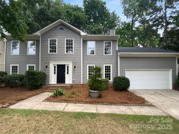 Charming two-story home with grey siding, black front door, and a well-manicured front yard at 10518 Fairway Ridge Rd, Charlotte, NC 28277