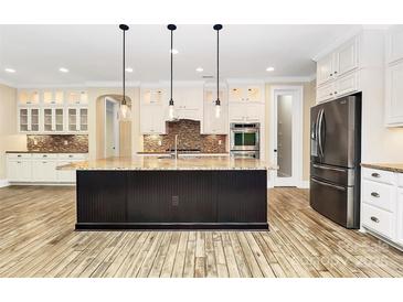 A spacious kitchen featuring a large island with granite countertops and stainless steel appliances at 11052 Preservation Park Dr, Charlotte, NC 28214