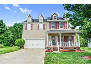 Charming two-story home featuring a front porch, manicured lawn, and attached garage at 1503 Stoney Ct, York, SC 29745