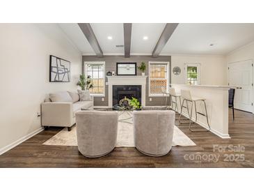 Inviting living room featuring a cozy fireplace, beamed ceilings, and a stylish seating arrangement at 1776 Baylor Dr, Rock Hill, SC 29732