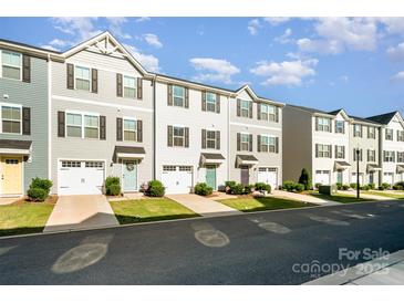 Charming townhomes with garages, colorful doors, and manicured lawns offer appealing curb appeal at 2037 Langer St, Charlotte, NC 28214