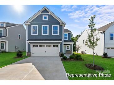 Charming two-story home with a blue exterior, manicured lawn, and an attached two-car garage at 32562-B Millingport Rd # 7155, New London, NC 28127