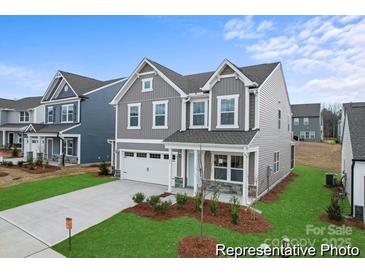 Charming two-story home with stone accents, a white garage door, landscaped yard, and craftsman architecture at 32616 Millingport Rd # 7144, New London, NC 28127